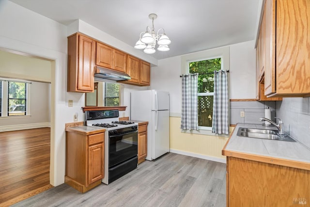 24 S University St, Healdsburg, CA 95448 - kitchen with range with gas stovetop, under cabinet range hood, freestanding refrigerator, a sink, and light wood-style flooring