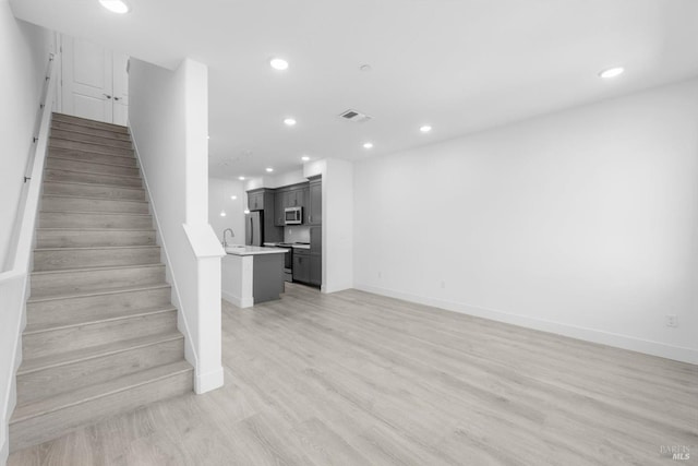 339 Pear Tree Ter Unit C, Napa, CA 94558 - unfurnished living room with recessed lighting, stairs, a sink, baseboards, and light wood-type flooring