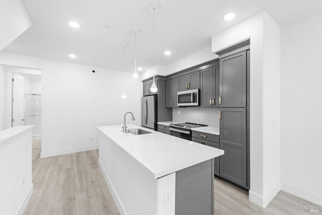339 Pear Tree Ter Unit C, Napa, CA 94558 - kitchen with stainless steel appliances, a sink, a center island with sink, light wood-style floors, and light countertops
