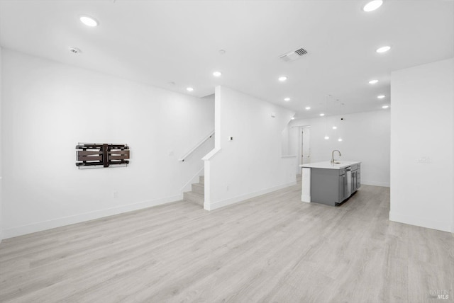 339 Pear Tree Ter Unit C, Napa, CA 94558 - unfurnished living room featuring a sink, recessed lighting, light wood-style flooring, and stairs