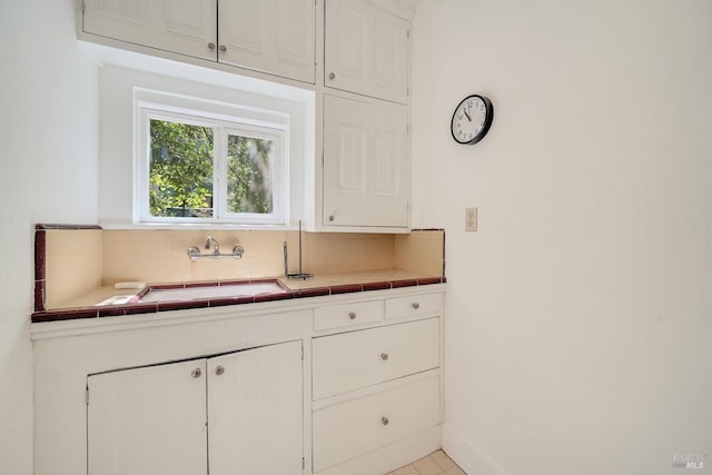 1423 Foothill Blvd, Calistoga, CA 94515 - kitchen with tile counters, tasteful backsplash, white cabinetry, and a sink