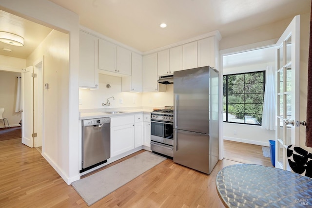 1423 Foothill Blvd, Calistoga, CA 94515 - kitchen with appliances with stainless steel finishes, under cabinet range hood, light wood-type flooring, and white cabinetry