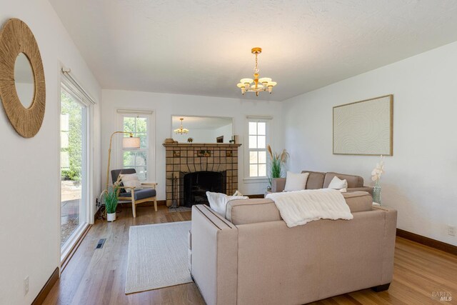 31 Laurel Ave, Petaluma, CA 94952 - living area featuring wood finished floors, a chandelier, baseboards, and a tiled fireplace