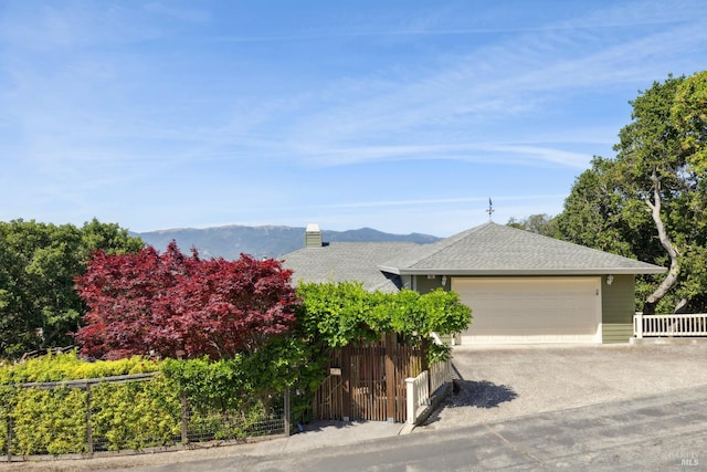 15 Upland Ln, Novato, CA 94945 - view of front of house featuring an attached garage, concrete driveway, a shingled roof, a chimney, and a mountain view