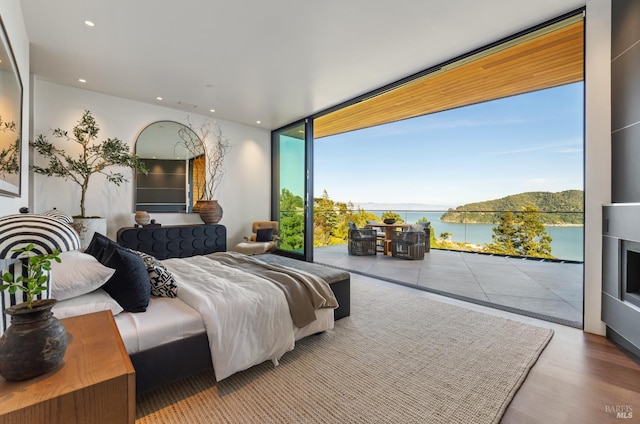 2215 Vistazo St E, Tiburon, CA 94920 - bedroom featuring access to outside, multiple windows, floor to ceiling windows, a water view, and wood finished floors