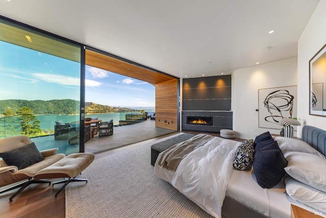 2215 Vistazo St E, Tiburon, CA 94920 - bedroom with access to outside, a fireplace, a wall of windows, a water view, and wood finished floors
