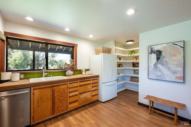 5900 Blank Rd, Sebastopol, CA 95472 - kitchen featuring stainless steel dishwasher, freestanding refrigerator, a sink, brown cabinets, and light wood-type flooring
