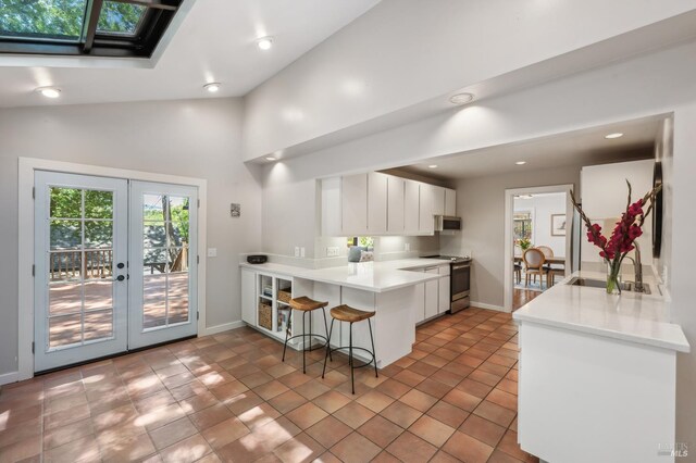 280 Oakcrest Rd, San Anselmo, CA 94960 - kitchen featuring appliances with stainless steel finishes, a sink, french doors, a peninsula, and a breakfast bar