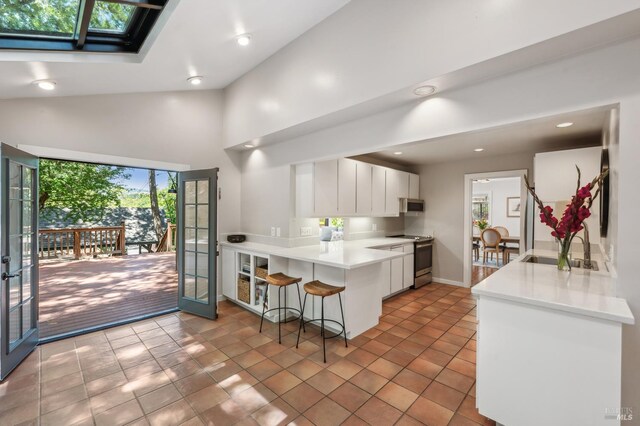 280 Oakcrest Rd, San Anselmo, CA 94960 - kitchen featuring stainless steel appliances, a sink, a peninsula, french doors, and a breakfast bar area