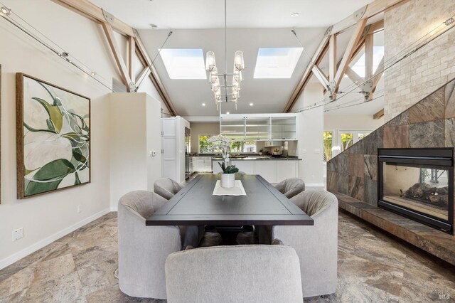 41 Cypress Rd, Point Reyes Station, CA 94956 - dining area with a skylight, baseboards, high vaulted ceiling, a tile fireplace, and light stone finish flooring