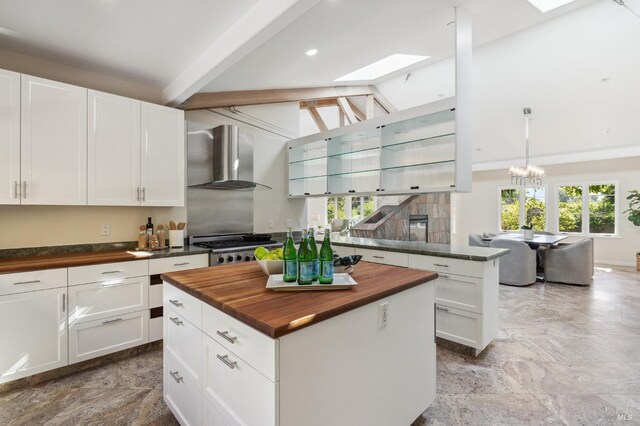 41 Cypress Rd, Point Reyes Station, CA 94956 - kitchen with butcher block countertops, wall chimney exhaust hood, a skylight, white cabinetry, and recessed lighting