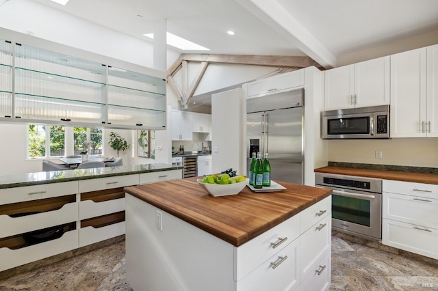 41 Cypress Rd, Point Reyes Station, CA 94956 - kitchen with stainless steel appliances, wooden counters, beverage cooler, beamed ceiling, and white cabinetry