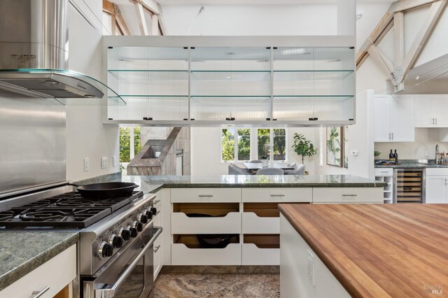 41 Cypress Rd, Point Reyes Station, CA 94956 - kitchen featuring stainless steel range, exhaust hood, wine cooler, butcher block counters, and white cabinetry