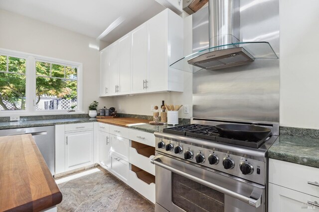 41 Cypress Rd, Point Reyes Station, CA 94956 - kitchen featuring stainless steel appliances, island range hood, wooden counters, white cabinets, and stone finish flooring