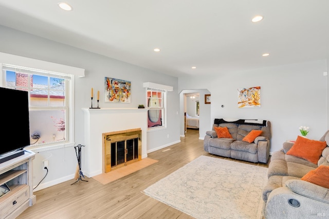 1225 Arkansas St, Vallejo, CA 94590 - living area with arched walkways, light wood-type flooring, a fireplace, recessed lighting, and baseboards