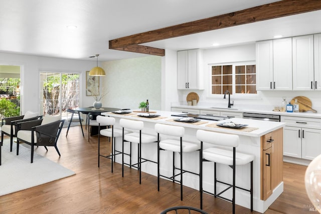 1109 Broadmoor Dr, Napa, CA 94558 - kitchen featuring a sink, a kitchen island, a kitchen breakfast bar, white cabinetry, and beamed ceiling