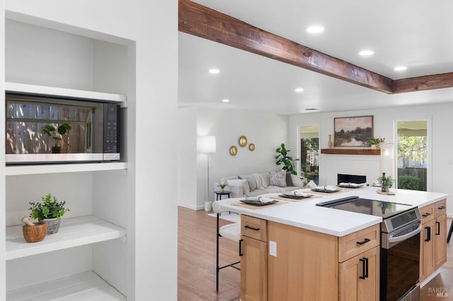 1109 Broadmoor Dr, Napa, CA 94558 - kitchen with electric stove, light brown cabinetry, a fireplace, open floor plan, and recessed lighting