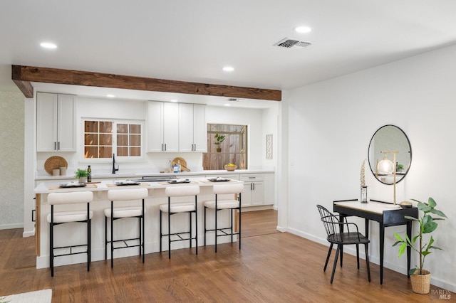 1109 Broadmoor Dr, Napa, CA 94558 - kitchen featuring beam ceiling, a sink, a breakfast bar area, white cabinets, and recessed lighting
