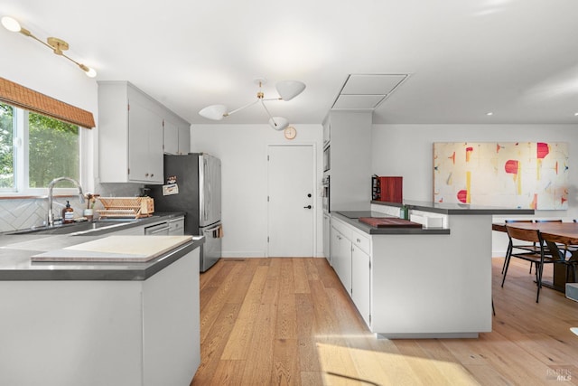 21800 River Rd, Geyserville, CA 95441 - kitchen with a sink, a peninsula, stainless steel appliances, and light wood finished floors