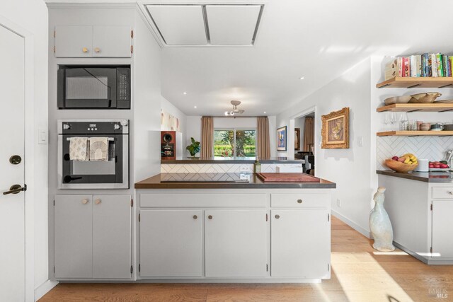 21800 River Rd, Geyserville, CA 95441 - kitchen with oven, black microwave, backsplash, dark countertops, and a peninsula
