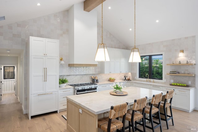 1597 Arrowhead Dr, Saint Helena, CA 94574 - kitchen with high vaulted ceiling, range with two ovens, a kitchen island, light wood finished floors, and white cabinetry