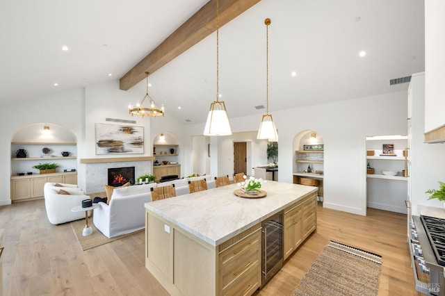 1597 Arrowhead Dr, Saint Helena, CA 94574 - kitchen with beverage cooler, a warm lit fireplace, built in shelves, a kitchen island, and beam ceiling