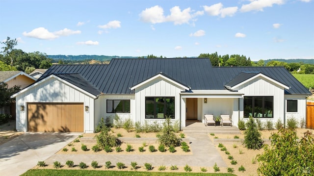 1597 Arrowhead Dr, Saint Helena, CA 94574 - modern inspired farmhouse with board and batten siding, an attached garage, metal roof, a porch, and concrete driveway