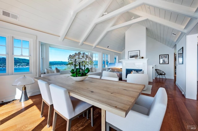 22 Eucalyptus Rd, Belvedere, CA 94920 - dining space featuring dark wood-style floors, a fireplace, beamed ceiling, baseboards, and high vaulted ceiling