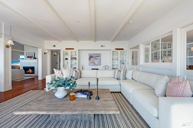 22 Eucalyptus Rd, Belvedere, CA 94920 - living area featuring beam ceiling, wood finished floors, and a warm lit fireplace