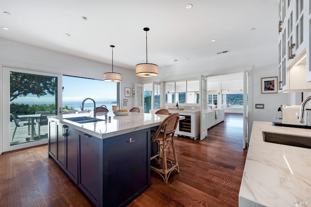 22 Eucalyptus Rd, Belvedere, CA 94920 - kitchen featuring a sink, dark wood-style floors, an island with sink, light stone countertops, and recessed lighting