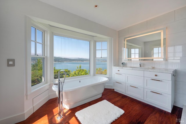 22 Eucalyptus Rd, Belvedere, CA 94920 - bathroom featuring wood finished floors, vanity, a freestanding tub, and a water view