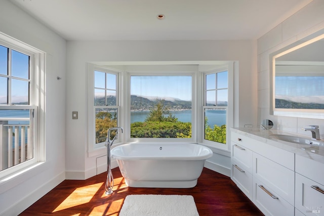 22 Eucalyptus Rd, Belvedere, CA 94920 - full bath with a freestanding bath, wood finished floors, baseboards, vanity, and a water view