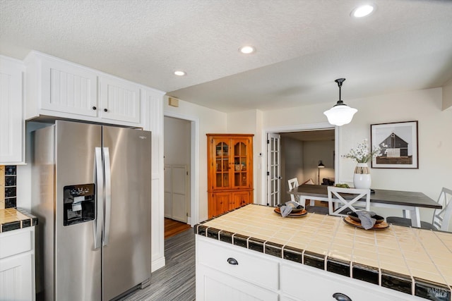 632 E K St, Benicia, CA 94510 - kitchen featuring stainless steel fridge, tile counters, white cabinets, recessed lighting, and hanging light fixtures