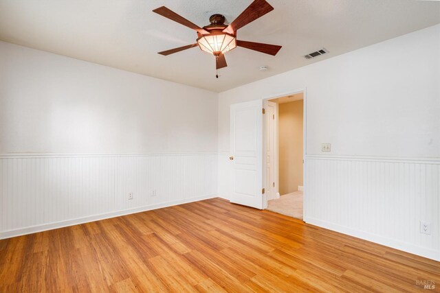 632 E K St, Benicia, CA 94510 - spare room featuring light wood finished floors, a wainscoted wall, and ceiling fan