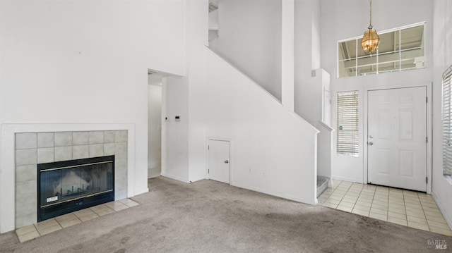 1191 Araquipa Ct, Vacaville, CA 95687 - carpeted foyer with a towering ceiling, baseboards, a chandelier, a tiled fireplace, and tile patterned flooring