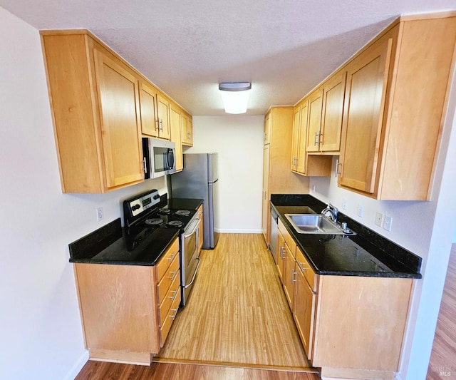900 Cambridge Dr Unit 122, Benicia, CA 94510 - kitchen featuring stainless steel appliances, a sink, light wood-style floors, baseboards, and dark stone countertops