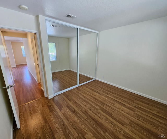900 Cambridge Dr Unit 122, Benicia, CA 94510 - unfurnished bedroom featuring dark wood-type flooring, baseboards, and a closet
