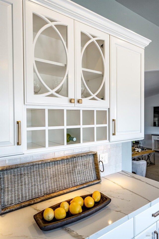 12 Maidu Ct, Napa, CA 94558 - kitchen view of white cabinetry, light stone countertops, tasteful backsplash, and glass insert cabinets
