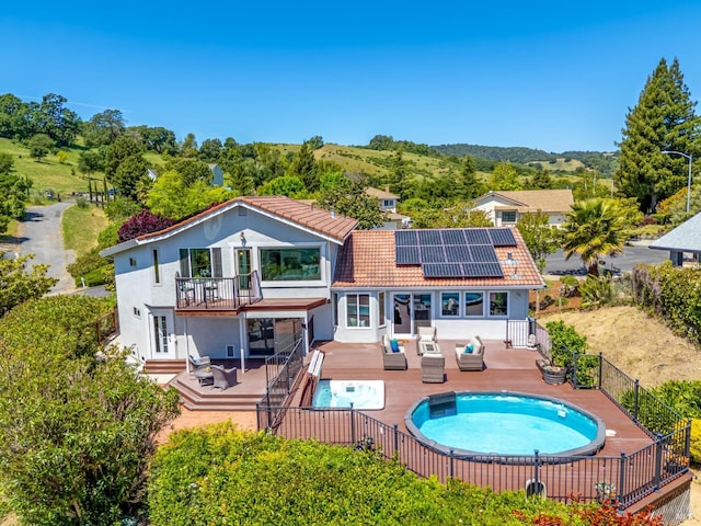 12 Maidu Ct, Napa, CA 94558 - back of property with a jacuzzi, a tiled roof, roof mounted solar panels, a fenced backyard, and an outdoor living space