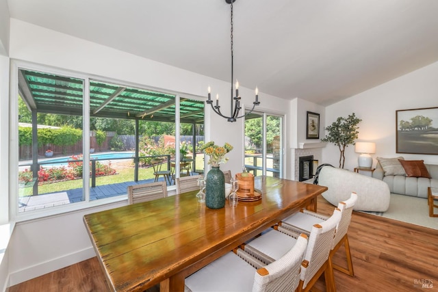 914 Cottonwood Ct, Petaluma, CA 94954 - dining room with lofted ceiling, wood finished floors, a chandelier, a fireplace, and baseboards