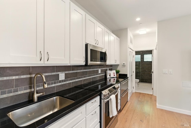 119 Marguerite Ave, Mill Valley, CA 94941 - kitchen featuring stainless steel appliances, a sink, dark countertops, baseboards, and white cabinets