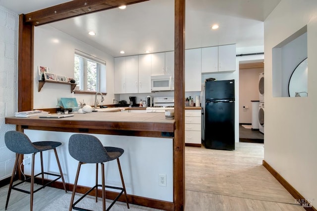 11 Inverness Way S, Inverness, CA 94937 - kitchen featuring white appliances, stacked washer and clothes dryer, tile countertops, a kitchen breakfast bar, and a peninsula