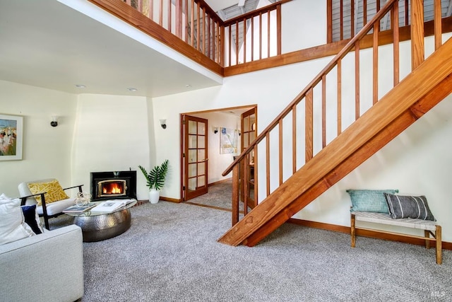 11 Inverness Way S, Inverness, CA 94937 - living room featuring carpet floors, stairway, a glass covered fireplace, baseboards, and a high ceiling
