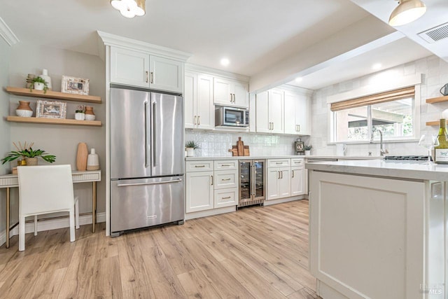37 Angela Ave, San Anselmo, CA 94960 - kitchen with stainless steel appliances, wine cooler, backsplash, light wood-style flooring, and white cabinetry