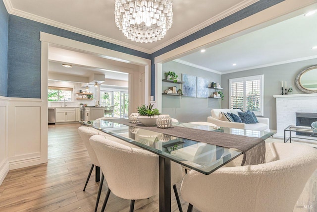 37 Angela Ave, San Anselmo, CA 94960 - dining room with a chandelier, light wood-style floors, a wainscoted wall, crown molding, and a fireplace