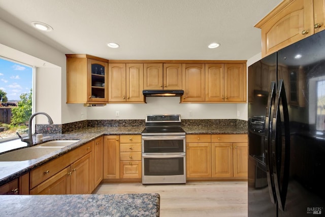 3327 Colonial Ct, Fairfield, CA 94534 - kitchen featuring black fridge with ice dispenser, range with two ovens, a sink, under cabinet range hood, and dark stone counters