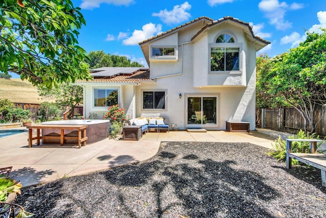 3327 Colonial Ct, Fairfield, CA 94534 - rear view of property with an outdoor hot tub, a tile roof, roof mounted solar panels, stucco siding, and a fenced backyard