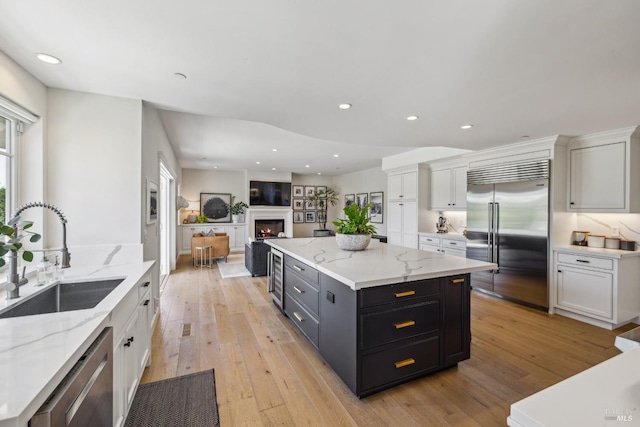 6 Live Oak Way, San Rafael, CA 94901 - kitchen with appliances with stainless steel finishes, a sink, white cabinets, light wood-type flooring, and a kitchen island