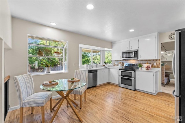 1503 Galaxy Ct, Rohnert Park, CA 94928 - kitchen featuring stainless steel appliances, light countertops, white cabinetry, tasteful backsplash, and light wood-style flooring