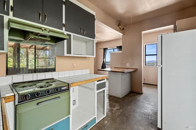 2840 Pear View Rd, Lakeport, CA 95453 - kitchen with freestanding refrigerator, under cabinet range hood, concrete floors, light countertops, and stovetop